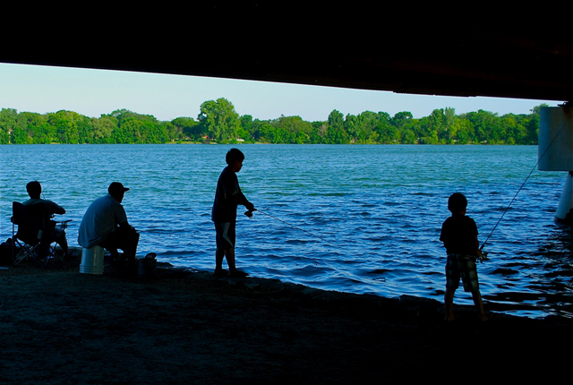 kids fishing along river